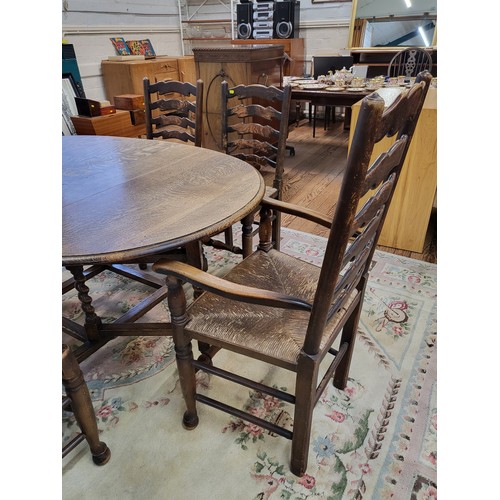 7 - An oak oval drop leaf dining table with barley twist legs and six matching dining chairs, ladder bac... 