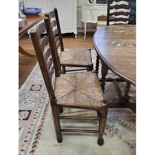 7 - An oak oval drop leaf dining table with barley twist legs and six matching dining chairs, ladder bac... 