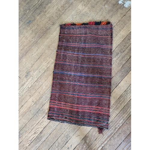 68 - A double stitched red, black, and orange rug. 117cm x 64cm.