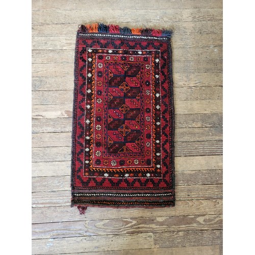 68 - A double stitched red, black, and orange rug. 117cm x 64cm.