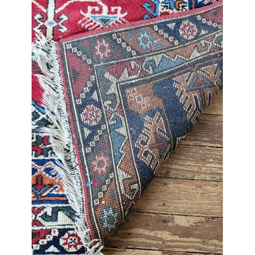 71 - A red and blue rug. 257cm x 149cm.