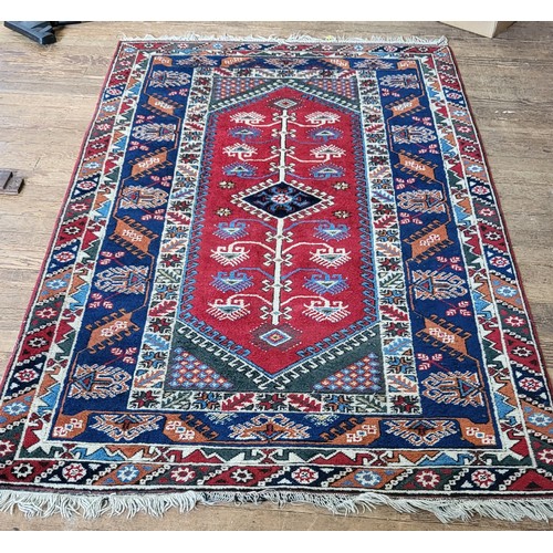 71 - A red and blue rug. 257cm x 149cm.