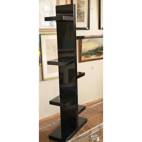 50 - A black shelving tower with staggered shelves. 187cm x 72cm x 28cm