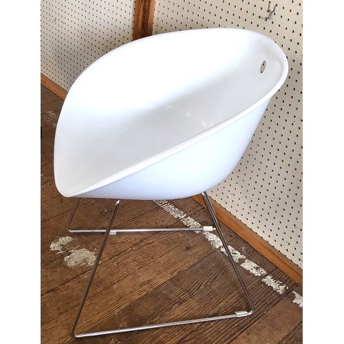 57 - A vintage style white tub chair, supported on shaped stainless steel lets.