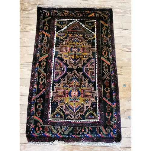 74 - A small 100% wool rug, polychrome design, bordered and fringed.