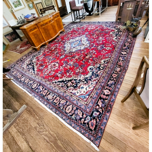 76 - A large red and blue ground rug with central medallion design, multi-bordered and fringed. 330cm x 4... 