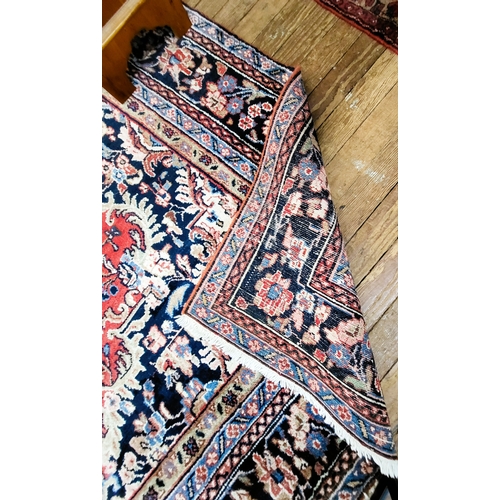 76 - A large red and blue ground rug with central medallion design, multi-bordered and fringed. 330cm x 4... 