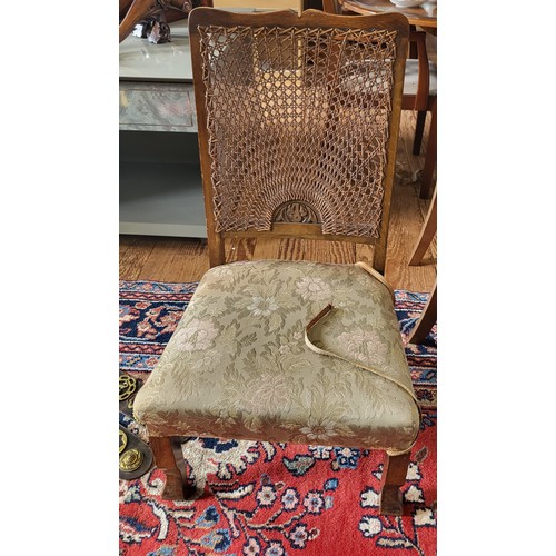 66 - A rattan-backed low bedroom chair, with fabric upholstered seat, on shaped legs.