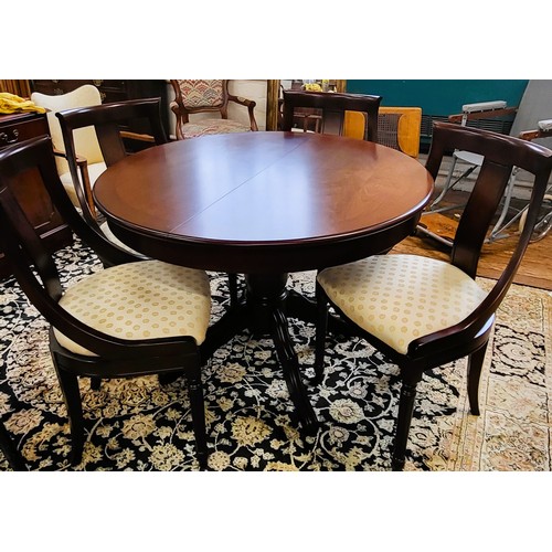 42 - A circular extendable reproduction table and four chairs, table is 112cm with a single centre stand ... 