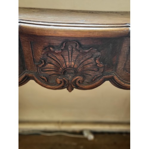 26 - An antique style oak serpentine fire surround, 107cm x 143cm x 33cm.