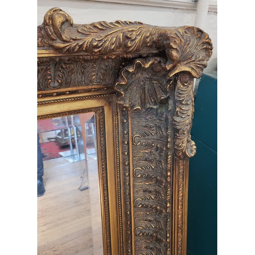 47 - A large ornate bevelled mirror with gilt scrolling. 150cm x 120cm.