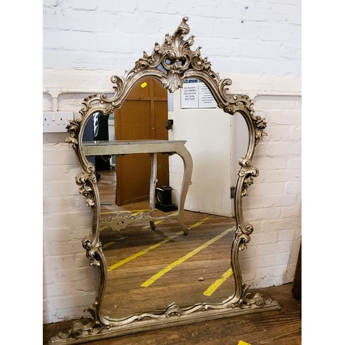 48 - A large mirrored console table, in French Baroque style, with marble top and silver painted wooden l... 