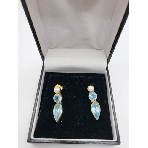 336 - A pair of silver gilt, blue topaz and pearl drop earrings, the articulated mounts set with pear-cut ... 