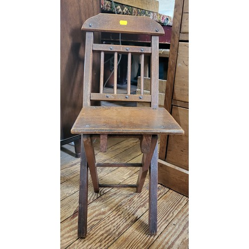 13 - An Egyptian brass table top with barley twist legs, together with an oak child's chair. (2)