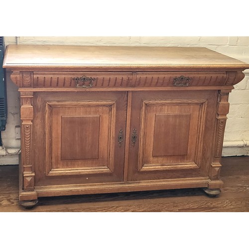 71 - A large blonde oak sideboard, with carved decoration, with key. 93cm x 148cm x 73cm