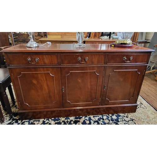 68 - A large mahogany sideboard with three drawers over three cupboards. 79cm x 140cm x 40cm.