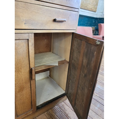 44 - An oak mid-century cabinet with two drawers over two doors 123cm x 83cm x 47cm.