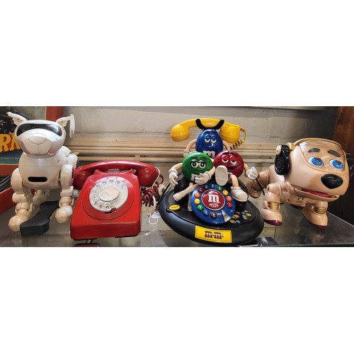 122 - A red telephone, a PF Products M&M's telephone and two toy space puppies (one ear incomplete). (4)