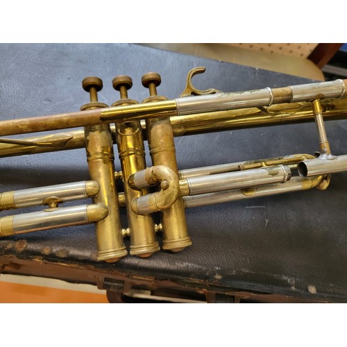 141 - A cased Emporor trumpet made by Boosey & Hawkes Ltd, London, with books and a cased  trombone engrav... 