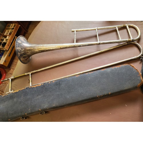 141 - A cased Emporor trumpet made by Boosey & Hawkes Ltd, London, with books and a cased  trombone engrav... 