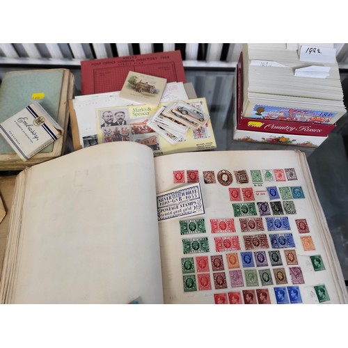 235 - A  collection of postcards and cigarette cards, an album of world stamps, a book titled 'Annual Regi... 