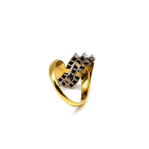 242 - A yellow metal and diamond crossover ring, the textured shoulders set with three rows of round brill... 