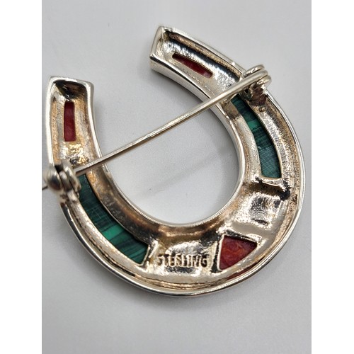 268 - A silver horseshoe brooch set with malachite and red jasper. 6g. 3.5cm x 3cm.