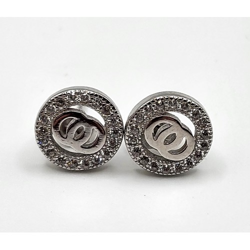 270 - A pair of silver and cubic zirconia designer style stud earrings. 1cm.