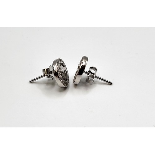 270 - A pair of silver and cubic zirconia designer style stud earrings. 1cm.