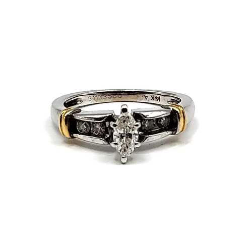 271 - A 14k mixed gold ring set with central Marquise cut diamond approx 1/2 ct. with four round brilliant... 