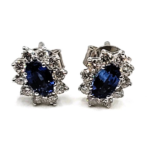 272 - A pair of 18ct white gold sapphire and diamond cluster earrings of 1.1cts total. Approc 0.8cm x 0.6c... 