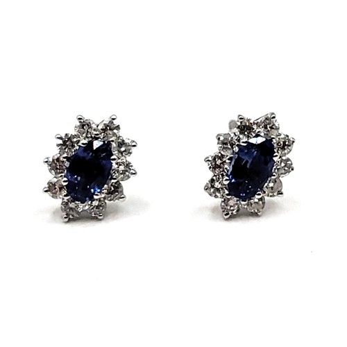 272 - A pair of 18ct white gold sapphire and diamond cluster earrings of 1.1cts total. Approc 0.8cm x 0.6c... 