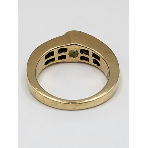 273 - A 14k yellow gold peridot and princess cut diamond ring. 9g. Ring size N 1/2