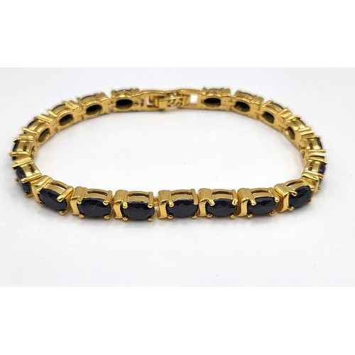 278 - A gold plated on silver and oval sapphire line bracelet.