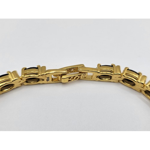 278 - A gold plated on silver and oval sapphire line bracelet.