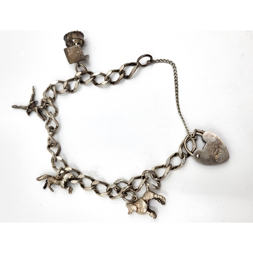 284 - A 1979 silver charm bracelet with four charms (well, poodle, ballerina and horse) and locket clasp, ... 