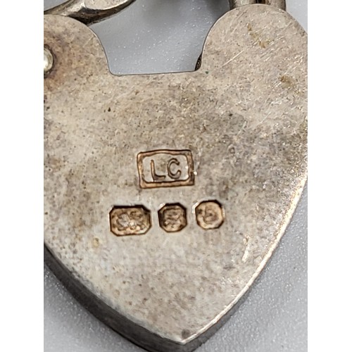 284 - A 1979 silver charm bracelet with four charms (well, poodle, ballerina and horse) and locket clasp, ... 