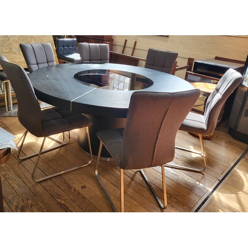 30 - An unusual large black circular table with a tempered glass lazy susan insert, on a circular pedesta... 