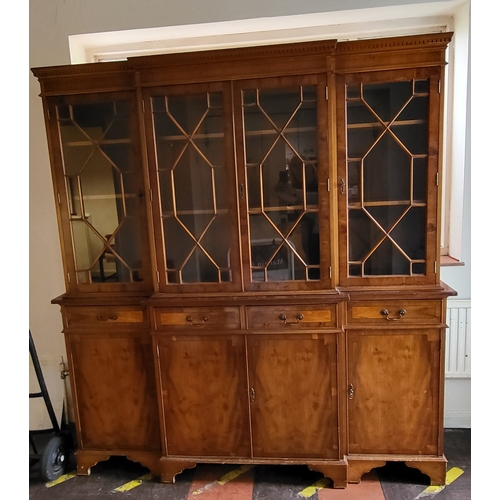 37 - A break front bookcase cabinet with four mullioned glass doors over four drawers and four lockable d... 