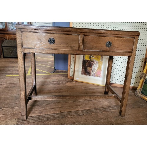 10 - An oak hall table with two drawers and on an H stretcher. 83cm x 100cm x 50cm.