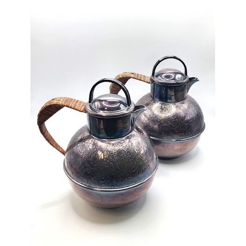 194 - A pair of silver plate tea pots, two pint capacity, with bamboo woven handles and ornately machine-e... 