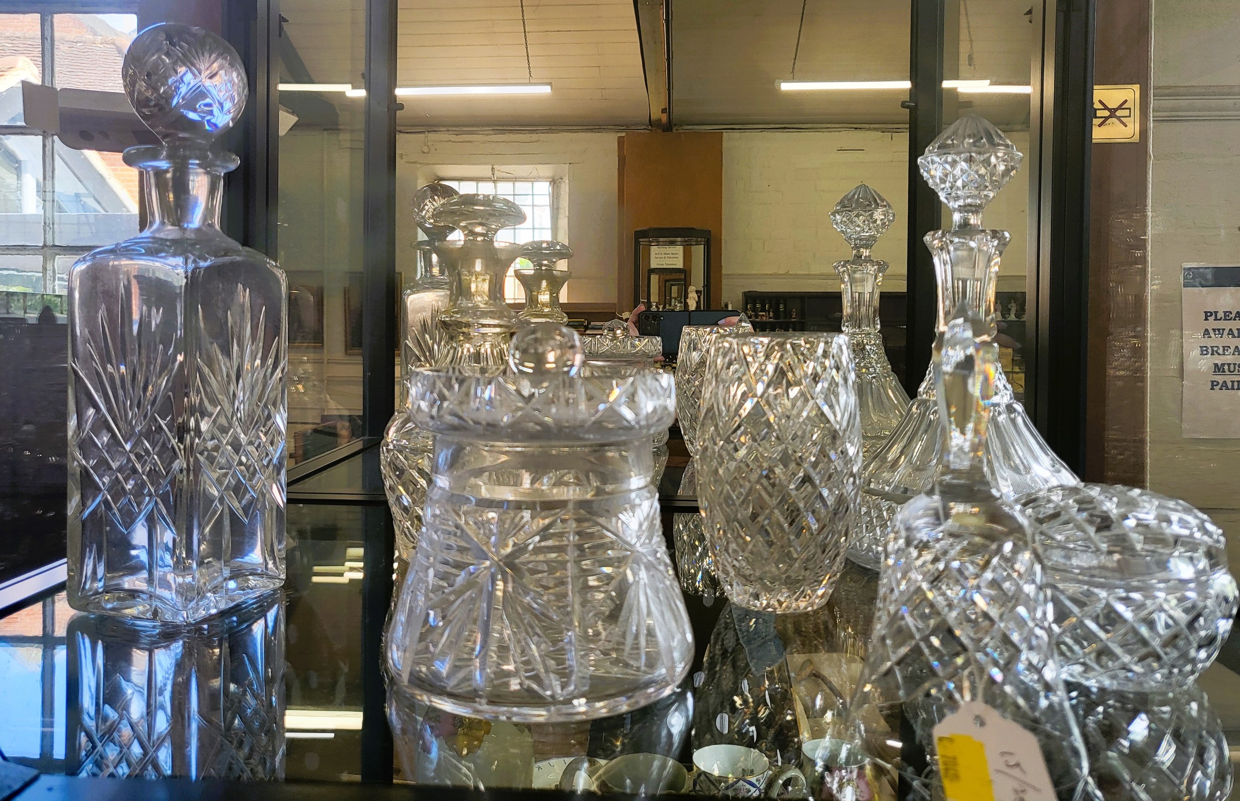 Three glass decanters with stoppers, two lidded jars, vase and a glass