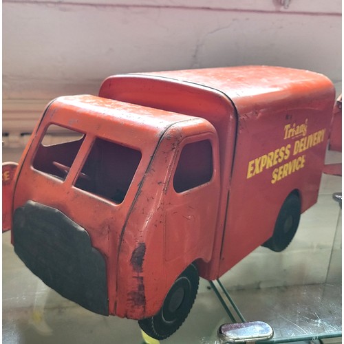 112 - Four Triang red painted steel trucks. (4)