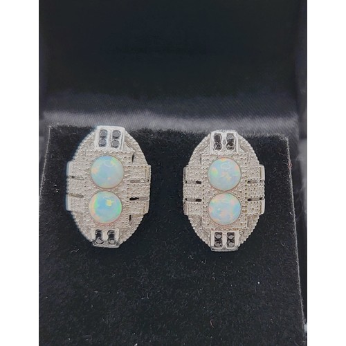 269 - A pair of man-made opal stud earrings on silver posts 1.3gms.