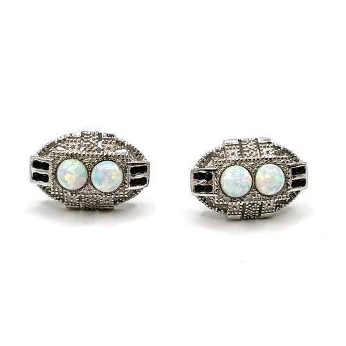 269 - A pair of man-made opal stud earrings on silver posts 1.3gms.