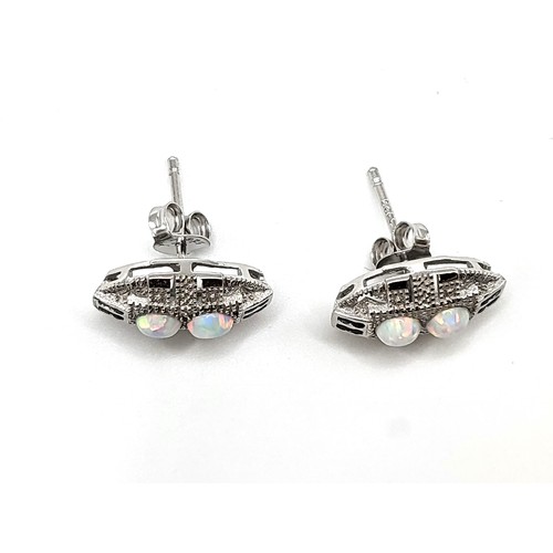 269 - A pair of man-made opal stud earrings on silver posts 1.3gms.