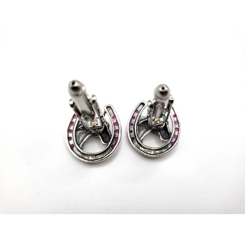 275 - A pair of silver and synthetic ruby set horseshoe shape cufflinks. 2cm x 1.7cm 10gms