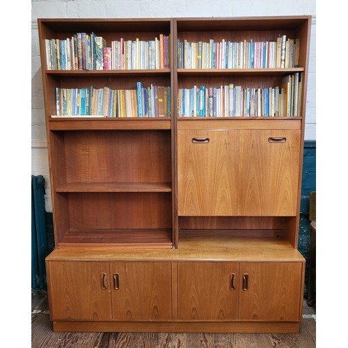 12 - A G-Plan wall unit with a mirrored cocktail cabinet with glass shelf, and shelving over four doors. ... 