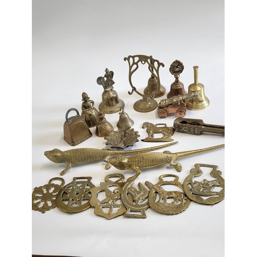 120 - A collection of brassware including various bells, a cannon, horse brasses and two lizards.