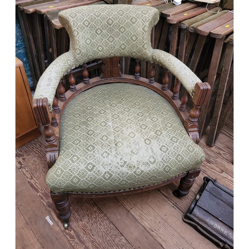 24 - An Edwardian tub shaped armchair. The chair features a curved back with turned balustrade spindles a... 